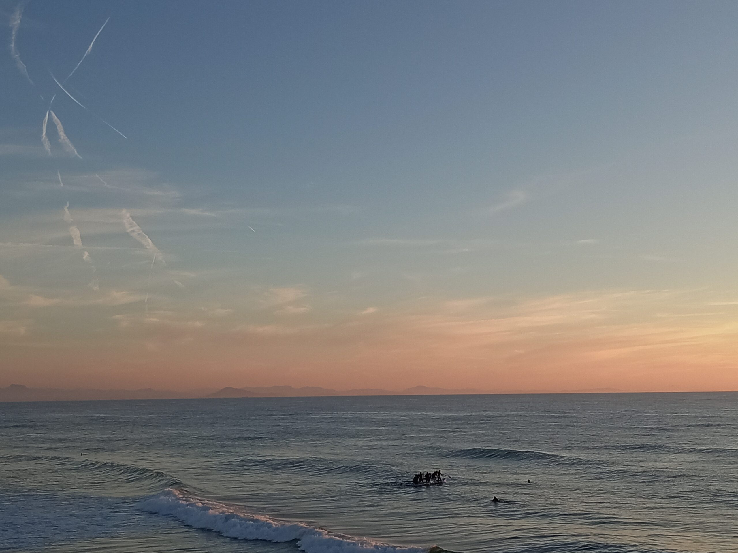 océan atlantique avec montagnes en fond et personnes qui font du paddle